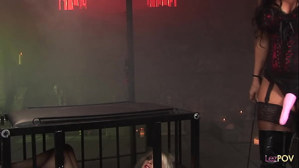 Lascivious lesbos in a dungeon fuck each other in a scene that resembles a BDMS session